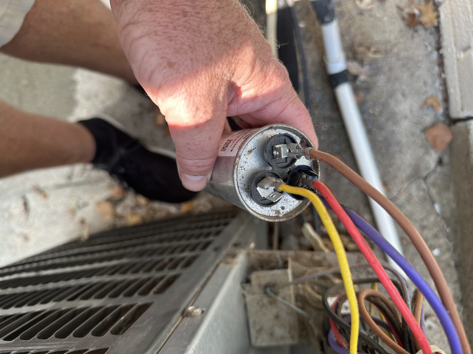 Holding the capacitor while moving the spade connectors onto its terminals